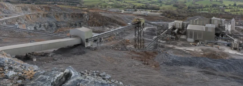 Mineral processing site beside an open quarry in the British countryside.